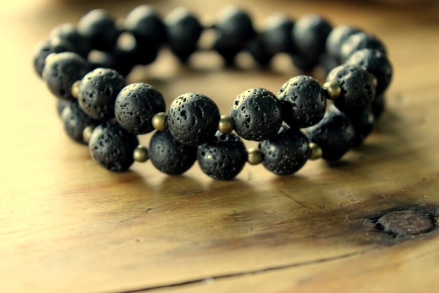 Lavas akmens aproce ar bronzas krāsas pērlītēm